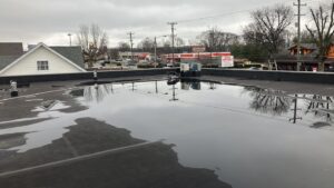 Ponding water on commercial roof in needs of roof maintenance and repair