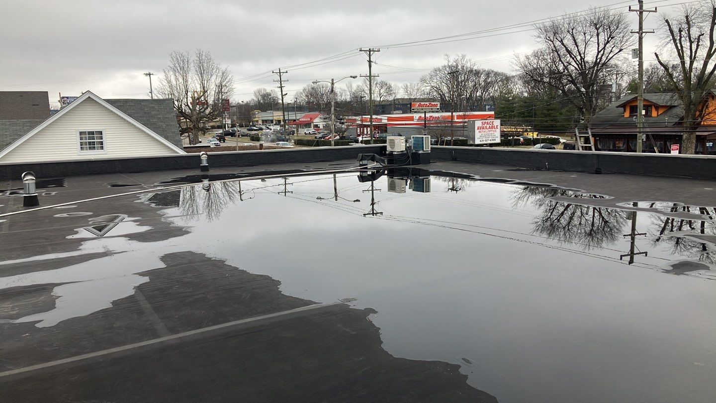Ponding water on commercial roof in needs of roof maintenance and repair