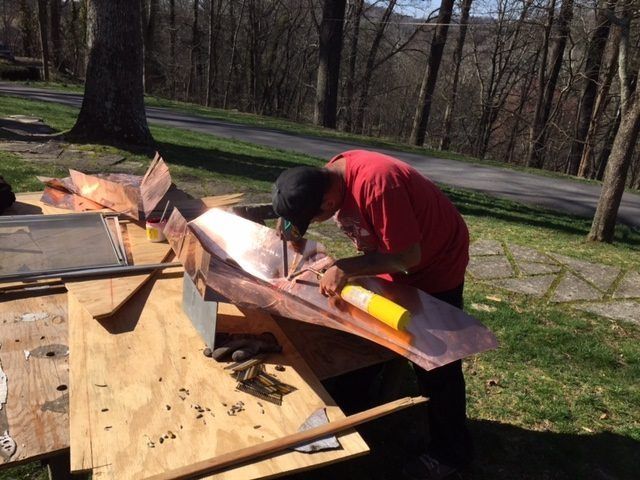 A man working on a wooden project outside.