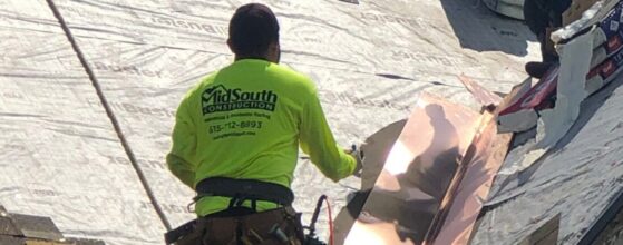 A MidSouth Construction worker installing copper flashing on a roof.