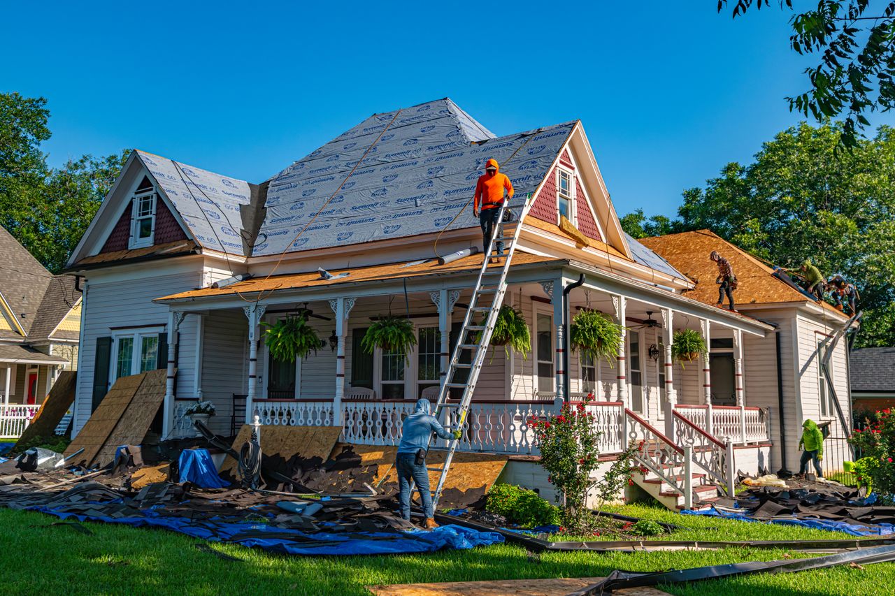 Roofers working on a vintage house.
