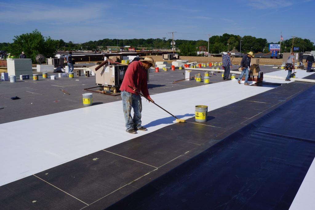 MidSouth Construction workers applying a fresh coat on a commercial flat roof