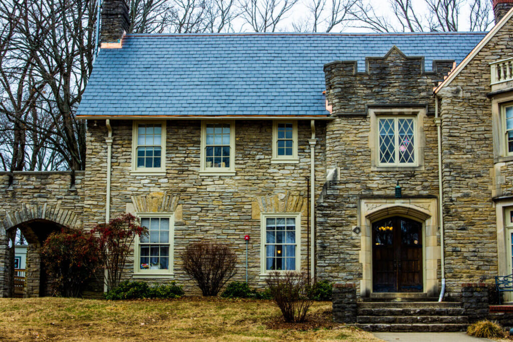 A large stone house with a blue slate roof — one of MidSouth Construction’s past projects