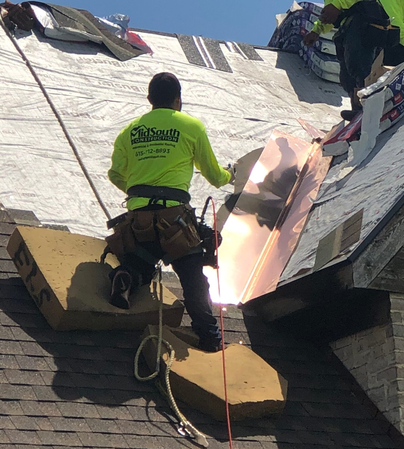 installing-copper-roof-flashing - MidSouth Construction LLC A roofer installing copper roof flashing