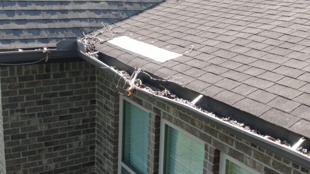 Picture showing lack of gutter maintenance causing issues to the roofing system and gutters
