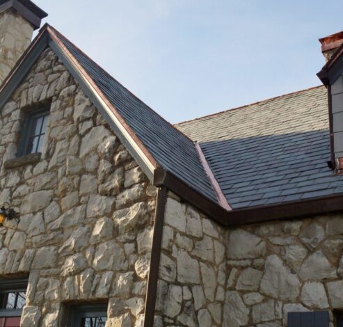 A stone house with a roof that has been cut in half.