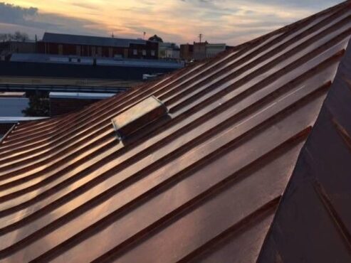 A close up of a copper standing seam roof of a building roofed by MidSouth Construction